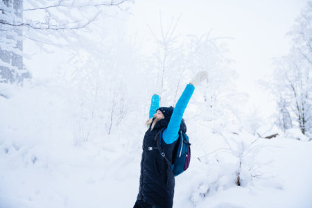 Woman tourist throws snow around her. Happy winter time.の写真素材