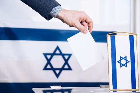 A mans hand votes at the ballot box. Policy. Choice.の写真素材