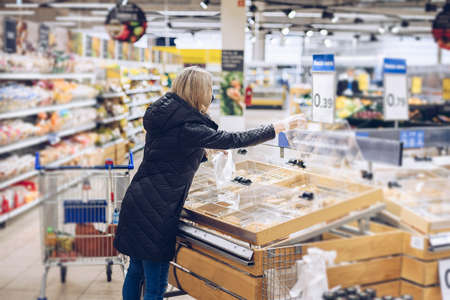 Woman on shopping. She choosing bakery products in supermarket.の写真素材