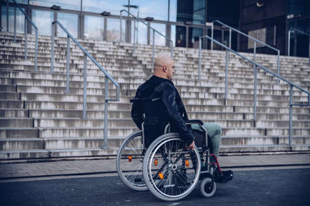 Paralyed man sitting on wheel chairin front of the stairsの写真素材