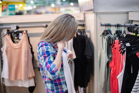Woman watches, tries on, buys clothes in a supermarket.の写真素材