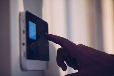 Mans hand unlocking and disarming the home security alarm.の写真素材