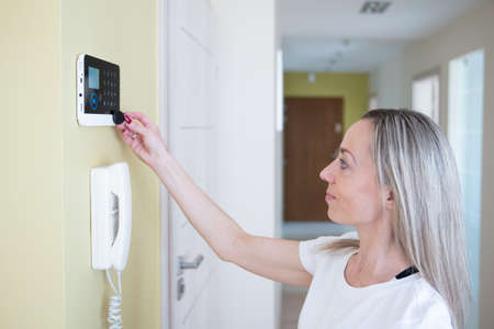 The woman disarms the security system at home.