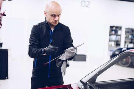 Man repairing car engine with his tools.