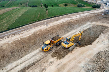 Aerial photo of an excavator and truck working on a construction.の写真素材