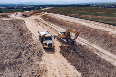Aerial drone view of excavator and tipper truck at the construction site.の写真素材