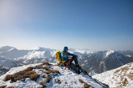 Hiker with backpack at the top of a mountain. Beautifull winter landscape.の写真素材