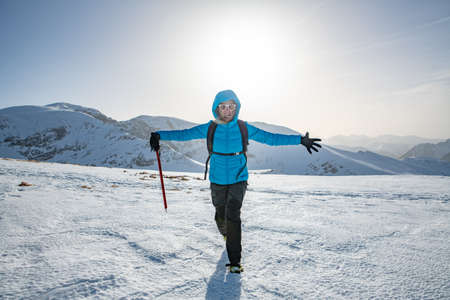 Female climber in the mountains with ice axe. Sunny day in mountains.の写真素材