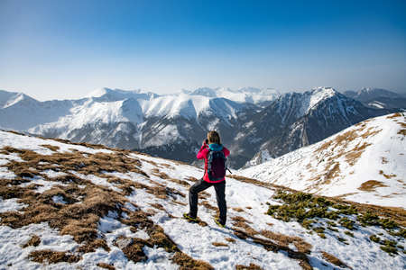Woman tourist in the mountains with a backpack. Active rest in one with nature.の写真素材