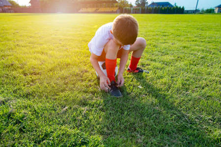 Young boy holding soccer ball. Playing football outdoors at green grass.の写真素材