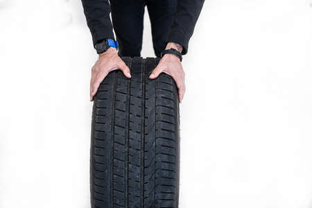 Mechanic holding car tire in seasonal tire change time