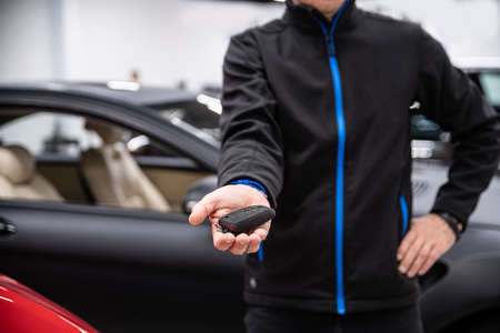 Car mechanic in service holding car keys