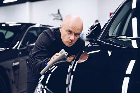 Car detailing studio worker polishing car paintの写真素材