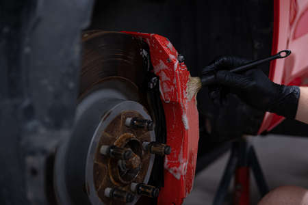 Man detailing studio worker cleaning brake caliperの写真素材