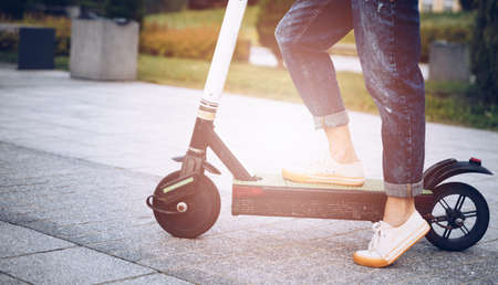 Close up of womans legs on her kick scooter.の写真素材