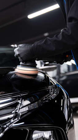 Car detailing studio technician polishing black car paintの写真素材
