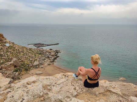 Beauty blonde woman resting after sports running in mountains.
