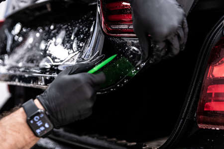 Car detailing technician applying transparent ppf foilの写真素材
