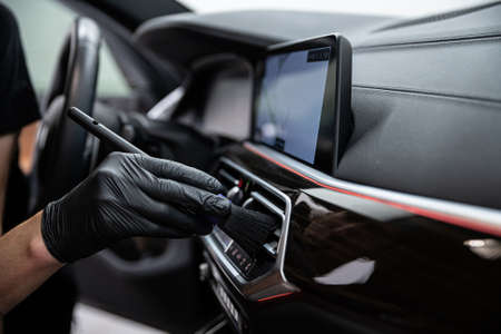 car detailing studio employee carefully cleans the air ventsの写真素材