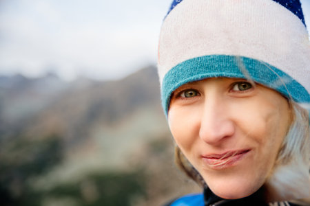Close up portrait of a beautiful blond woman with green eyes. A woman is wearing a hat