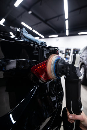 car wash or car detailing studio worker polishes the paintworkの写真素材