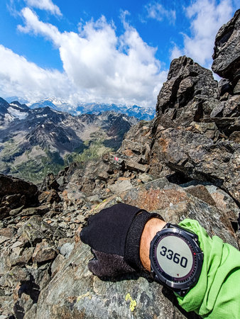 Man is showing the altitude on his sports smartwatch during a mountain hike