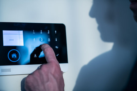 Thief or electronic hacker is trying to break into an apartment secured by an alarm systemの写真素材