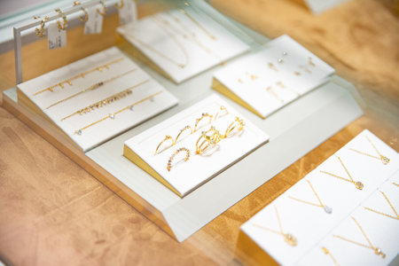 Elegant display of various gold jewelry pieces including necklaces, earrings, and ringsの写真素材