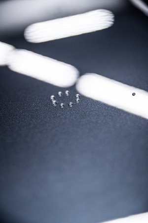 Close-up of water droplets beading on a dark car surface, demonstrating the hydrophobic effect
