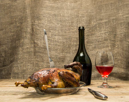 Roast duck and a glass of wine a wooden backgroundの写真素材