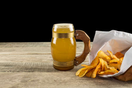 beer with potato chips on a wooden backgroundの写真素材
