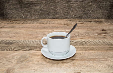 White cup of coffee on a wooden tableの写真素材
