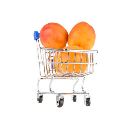 trolley from supermarket with apricot on isolated white backgroundの写真素材