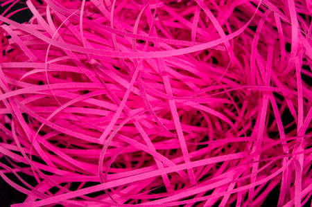 pink cut strips of paper on a black backgroundの写真素材