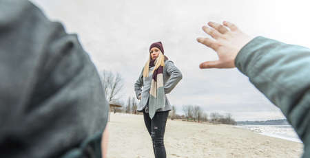 Young woman standing above a man on the groundの写真素材