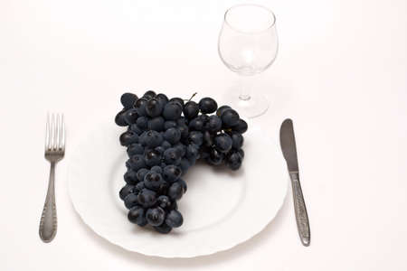  Black Grapes in plate isolated on whiteの写真素材