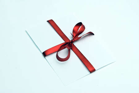 Blank gift tag tied with a bow of red satin ribbon. の写真素材