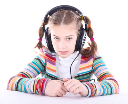 Happy little girl in headphones listens to musicの写真素材