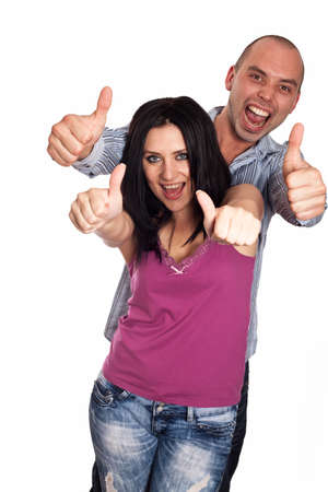 Two young smiling people with thumbs-up gesture isolated on whiteの写真素材