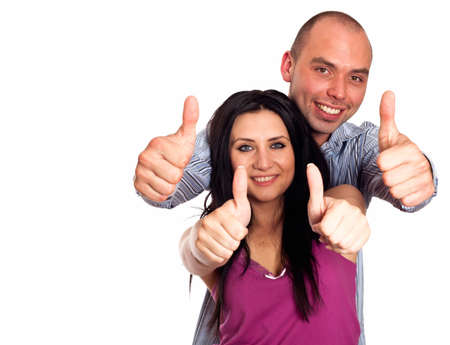 Two young smiling people with thumbs-up gesture isolated on whiteの写真素材