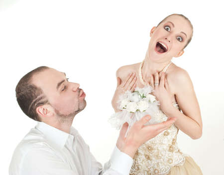 Beautiful  wedding couple - groom and surprised bride over white backgroundの写真素材