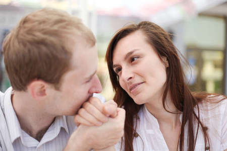 Young man kissing hand of his girlfriend on date