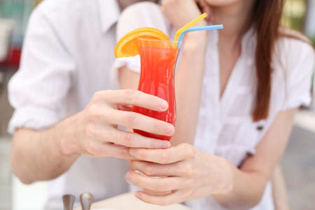 Young couple drinking juice in cafeの写真素材