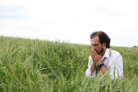 Man praying for good wheat yearの写真素材
