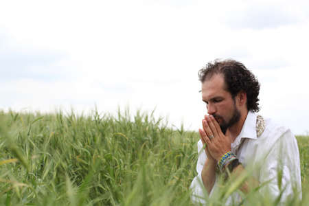 Man praying for good wheat yearの写真素材