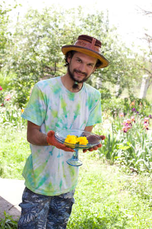 Man holding roses in vase in the gardenの写真素材