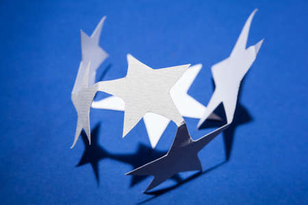 Paper christmas stars on the blue background .