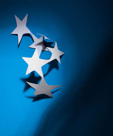 Paper christmas stars on the blue background .の写真素材