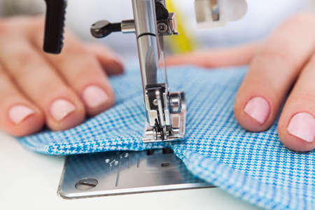 A sewer making a stitch on the fabricの写真素材