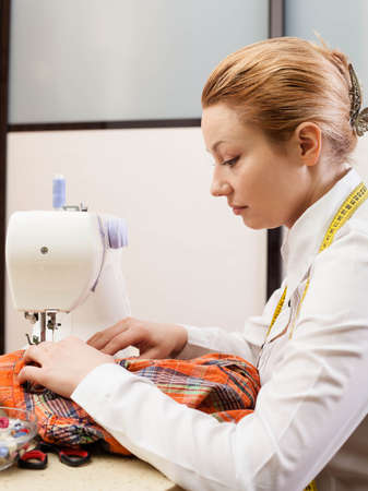 A sewer working on the sewing machine.の写真素材